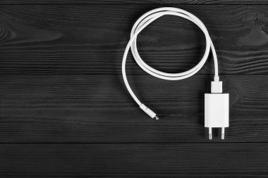 Ahşap arka planda kablo telefon şarj cihazları