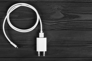Ahşap arka planda kablo telefon şarj cihazları