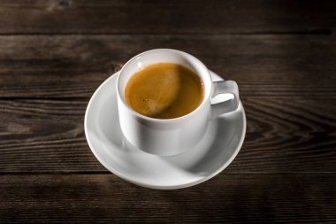 Siyah ahşap zemin üzerine beyaz fincan sade kahve