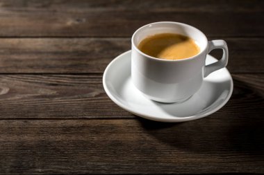 Siyah ahşap zemin üzerine beyaz fincan sade kahve