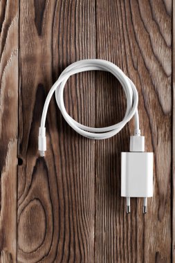 Ahşap arka planda kablo telefon şarj cihazları