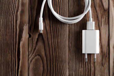 Ahşap arka planda kablo telefon şarj cihazları