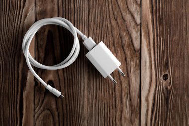 Ahşap arka planda kablo telefon şarj cihazları