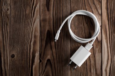 Ahşap arka planda kablo telefon şarj cihazları