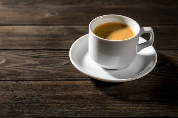 Siyah ahşap zemin üzerine beyaz fincan sade kahve
