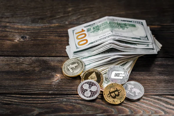 Ahşap zemin üzerinde bitcoin, dalgalanma ve ethereum sembollü gümüş ve altın sikkeler.