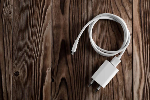 Ahşap arka planda kablo telefon şarj cihazları