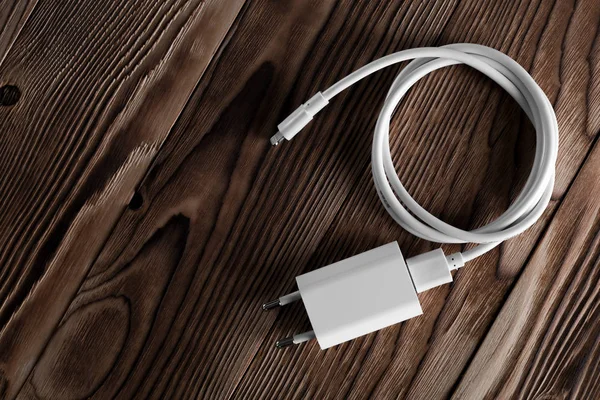 Ahşap arka planda kablo telefon şarj cihazları
