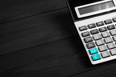 Siyah ahşap arka plan üzerinde izole hesap makinesi