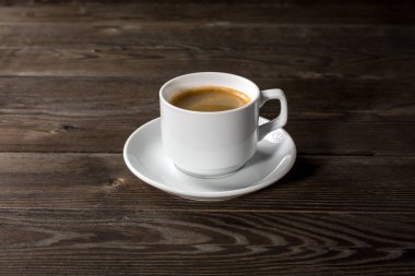 Siyah ahşap zemin üzerine beyaz fincan sade kahve