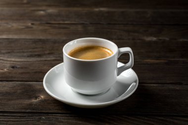 Siyah ahşap zemin üzerine beyaz fincan sade kahve