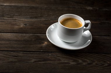 Siyah ahşap zemin üzerine beyaz fincan sade kahve