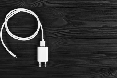 Ahşap arka planda kablo telefon şarj cihazları