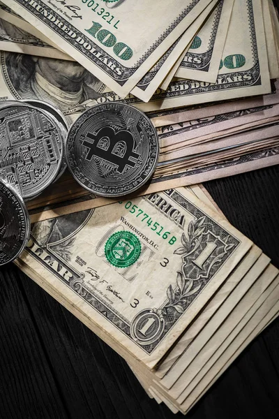 Ahşap zemin üzerinde bitcoin, dalgalanma ve ethereum sembollü gümüş ve altın sikkeler.