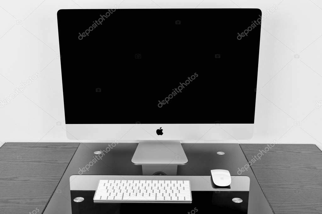 UKRAINE, RIVNE, October 11, 2018. Apple Computer iMac 27 retina display 5K keyboard and magic mouse on black table. Isolated on a white background