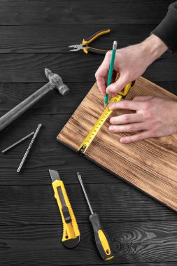 Marangoz atölyesinde ahşapla çalışır. 