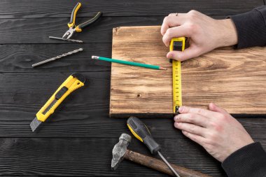 Marangoz atölyesinde ahşapla çalışır. 