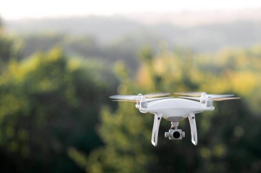 bir kamera ile bir göl üzerinde uçan quadcopter dron.