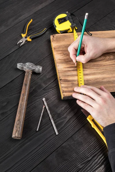 Marangoz atölyesinde ahşapla çalışır. 