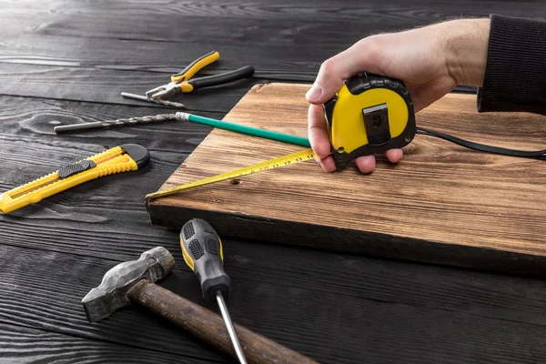 The carpenter works with wood on his workspace