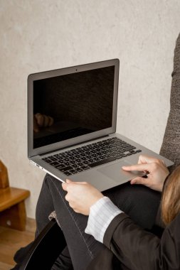 belgili tanımlık laptop ile kız evleri sandalyeye oturur