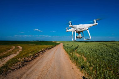 bir kamera ile bir göl üzerinde uçan quadcopter dron.