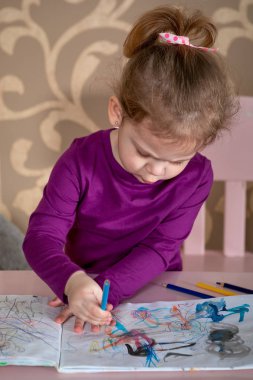 masada otururken keçeli kalem kullanarak çizim şirin çocuk