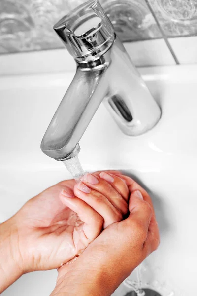 Washing hand under tap water