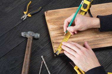 Marangoz atölyesinde ahşapla çalışır. 