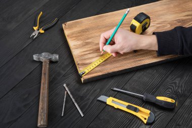 Marangoz atölyesinde ahşapla çalışır. 