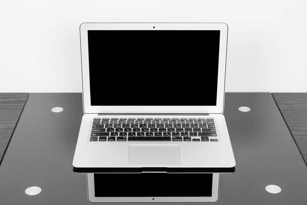 Рабочее место с ноутбуком на черном столе — стоковое фото