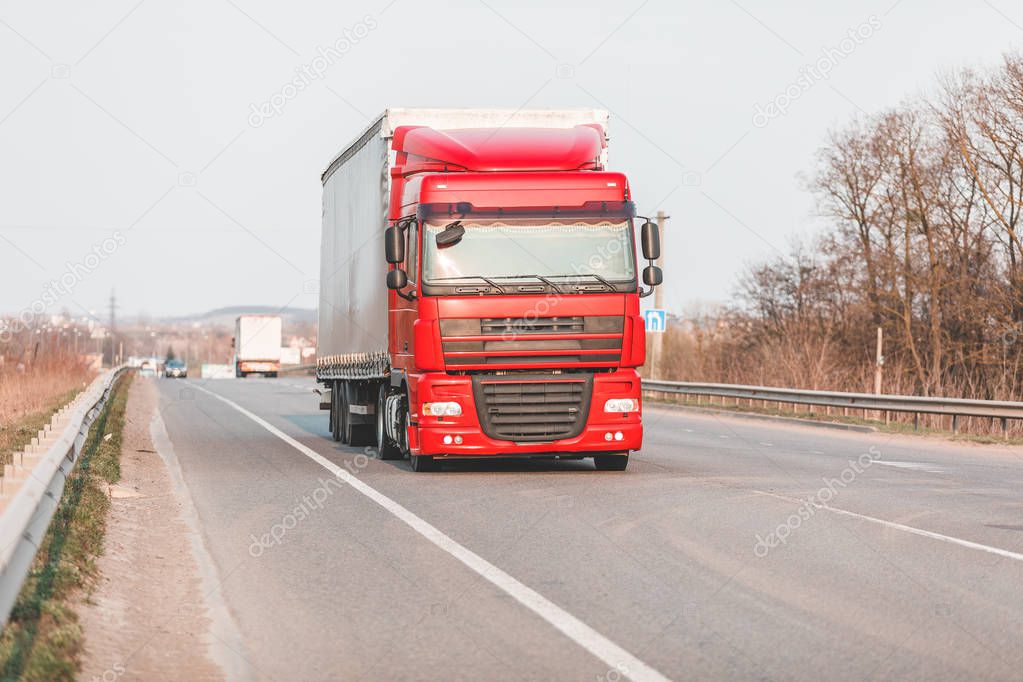 Arriving white truck on the road in a rural landscape at sunset