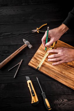 Marangoz atölyesinde ahşapla çalışır.