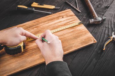 Marangoz atölyesinde ahşapla çalışır.