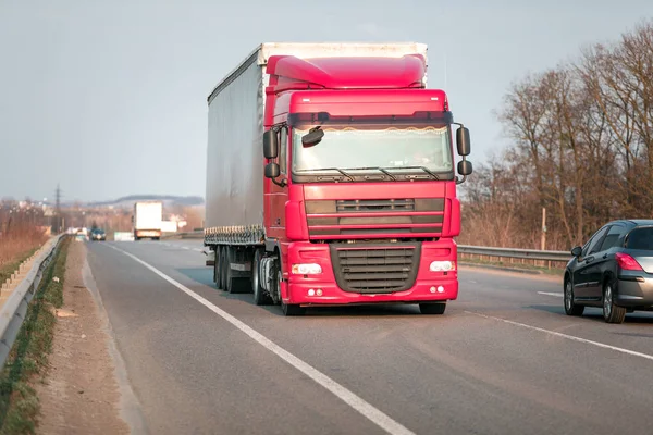 Aankomst witte vrachtwagen op de weg in een landelijk landschap bij zonsondergang — Stockfoto