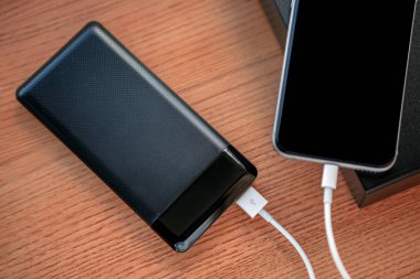 powerbank ücretleri akıllı telefon ahşap arka plan üzerinde izole