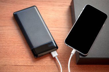 powerbank ücretleri akıllı telefon ahşap arka plan üzerinde izole