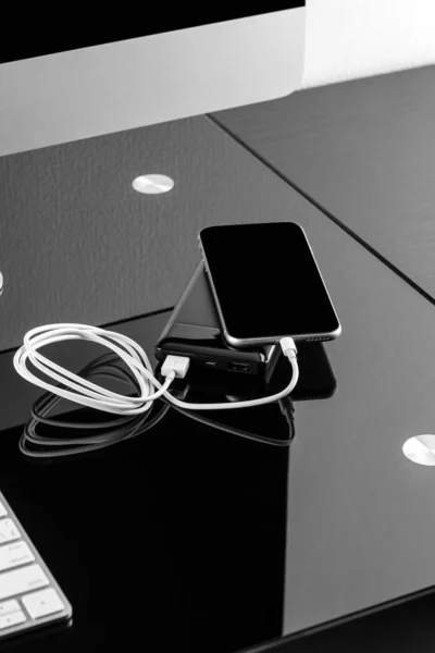 Powerbank заряжает смартфон изолированным на черном фоне — стоковое фото