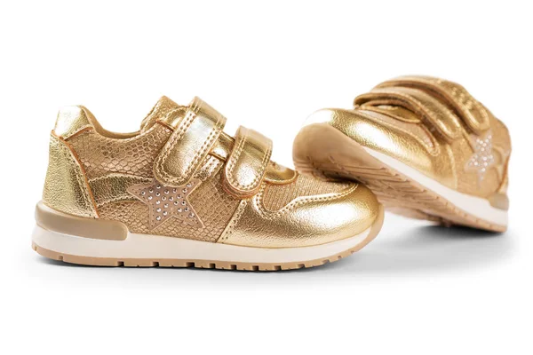 Platte lag. de gouden Kinder sportschoenen geïsoleerd op een witte b — Stockfoto