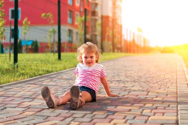 kaldırımda oturan küçük kız