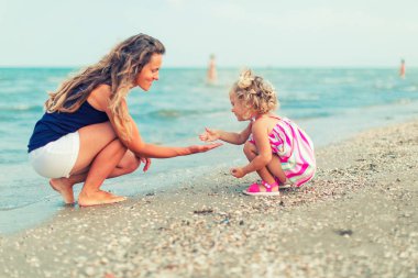 mutlu anne ve kızı deniz tatilinde oynarken