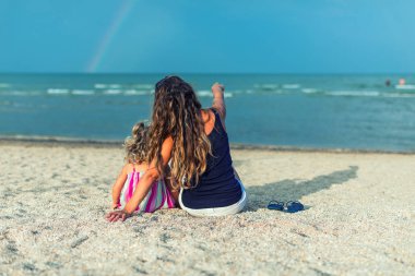 mutlu anne ve kızı deniz tatilinde oynarken