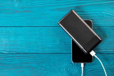 powerbank ücretleri akıllı telefon ahşap arka plan üzerinde izole