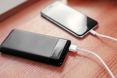 powerbank ücretleri akıllı telefon ahşap arka plan üzerinde izole