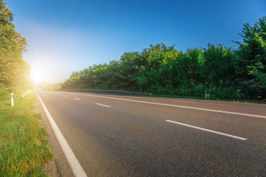 Asfalt yollar ve mavi gökyüzünün altındaki dağlar