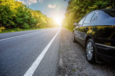 Siyah araba asfalt yolda.