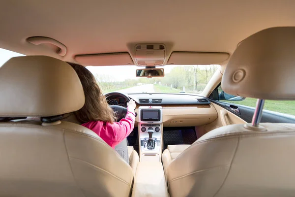 La mujer que conduce el coche moderno en el camino de asfalto hacia el — Foto de Stock