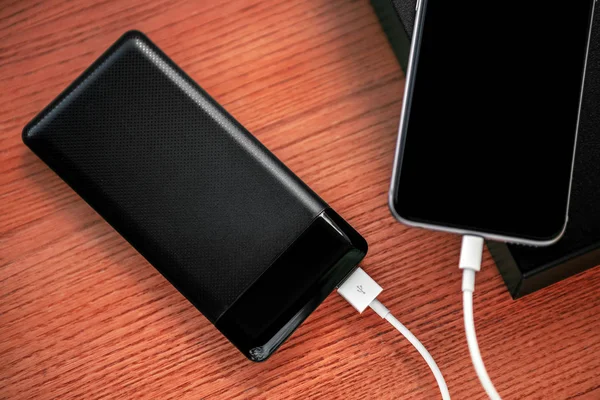 powerbank ücretleri akıllı telefon ahşap arka plan üzerinde izole