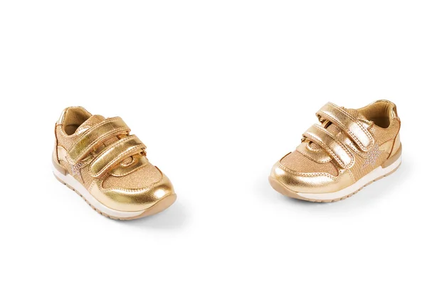 Плоский лежал. the gold children 's sports shoes isolated on a white b — стоковое фото