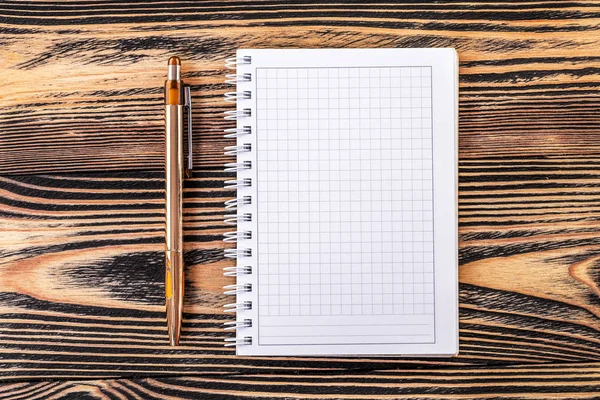 Kahverengi ahşap masa arka plan üzerinde kalem ile Not Defteri — Stok fotoğraf